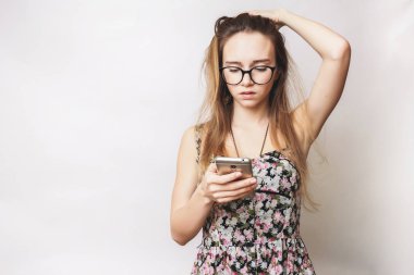 uzun saç ve gözlük ile genç güzel kız saçını dokunur ve telefona benziyor
