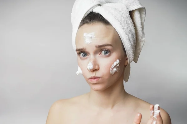 Close-up de bela jovem aplicando creme com toalha de banho na cabeça cobrindo seus seios, desfrutando — Fotografia de Stock