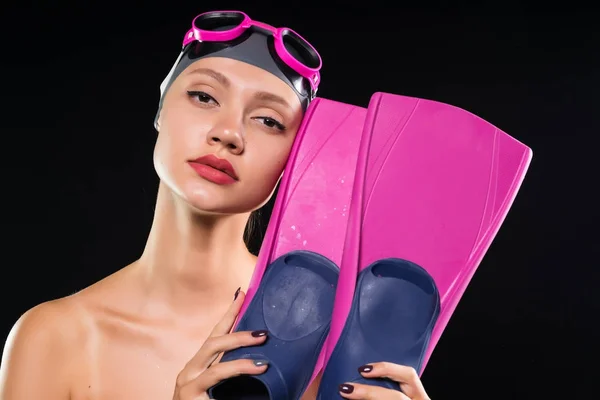 Mooi meisje in een zwemmen Pet en bril houdt flippers in handen — Stockfoto