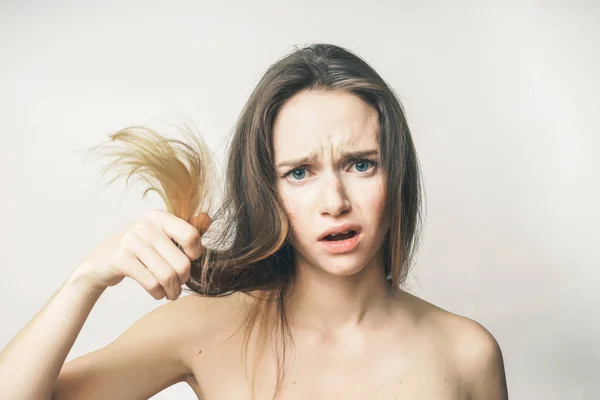 Mujer muestra las puntas secas del cabello poco saludable, cara de belleza, cuidado de la salud — Foto de Stock