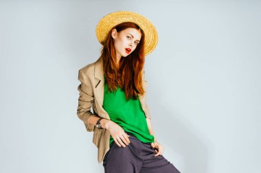 Kırmızı dudaklar ile ve büyük bir şapka kız kameraya görünüyor. Parlak Yeşil bluz, izole kadın