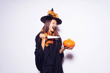 genç güzel seksi Gotik kız bir cadı Cadılar Bayramı için giyinmiş, onun elinde tutan bir kabak ve bir bıçak ve korkutucu görünüyor