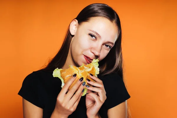 Roztomilá dívka chce zhubnout, ale jí nezdravé burger vysoce kalorické — Stock fotografie