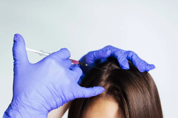 Uma jovem é dada uma injeção médica na cabeça para crescer e fortalecer o cabelo — Fotografia de Stock