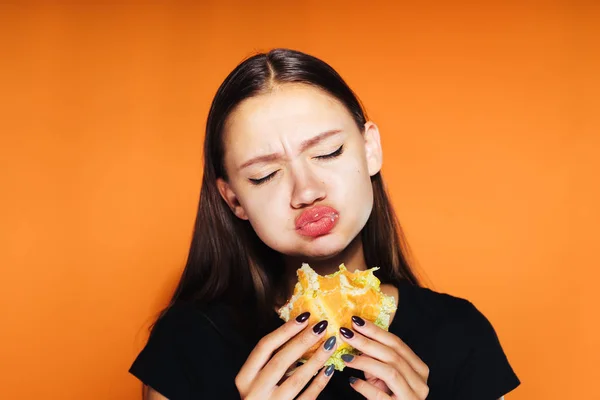 아름 다운 행복 소녀 무게를 잃고 싶어 하지만 열심히 유해한 칼로리 햄버거를 먹고 — 스톡 사진