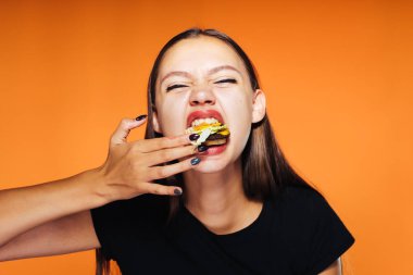 genç güzel kız kilo vermek istiyor, ama hevesle zararlı yüksek kalorili hamburger yiyor