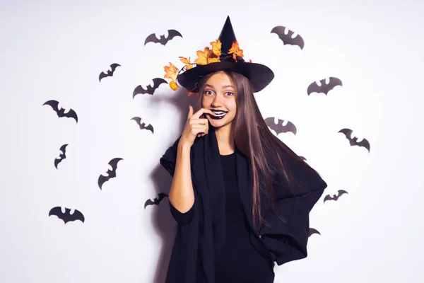 Sexy gothic meisje vieren halloween in het beeld van een heks, in een grote zwarte hoed, lachen — Stockfoto