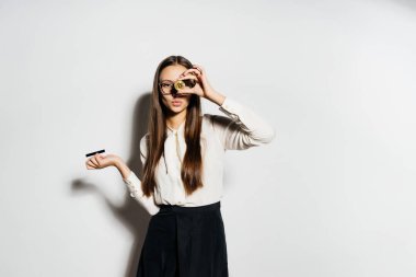 genç, başarılı ve modern bir kız altın bir bitcoin ve bir banka kartı elinde tutan