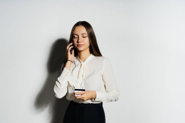 Gözlüklü genç başarılı modern kız bir banka kartı elinde tutan ve Kripto para birimi hakkında Evet