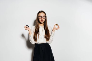 Gözlüklü genç başarılı modern kız altın bir bicoin ve bir banka kartı elinde tutan