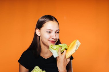 güzel kız, kilo vermek istiyor bir genç tutan onun el zararlı kalori beyaz ekmek ve sağlıklı Pekin lahana