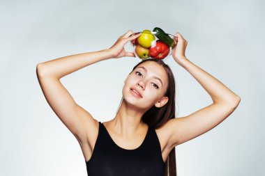 Siyah top bir genç atletik kız onu rakam tutar, bir tabak yararlı sebze ve meyve ile onun elinde tutan