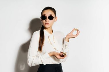 güneş gözlüklü genç modern başarılı kız altın bitcoins elinde tutar.