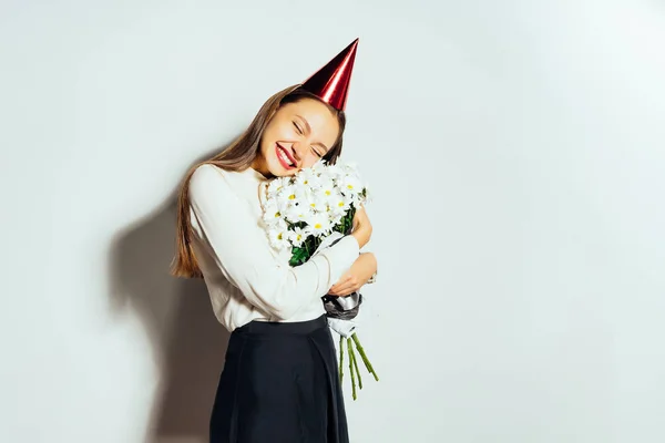 Jovem menina feliz comemorando algo, segurando um grande joanete branco de flores e sorrindo — Fotografia de Stock