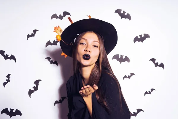 Mladá sexy dívka gothic slaví halloween, oblečený v čarodějnice, posílá polibek vzduchu — Stock fotografie