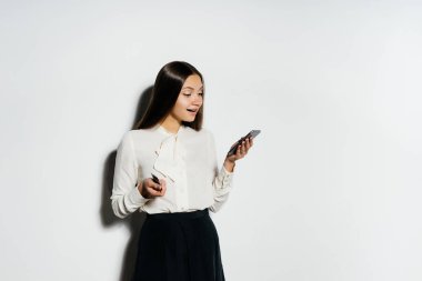 bir banka kartı tutan ve onun smartphone arıyorum genç başarılı modern kız