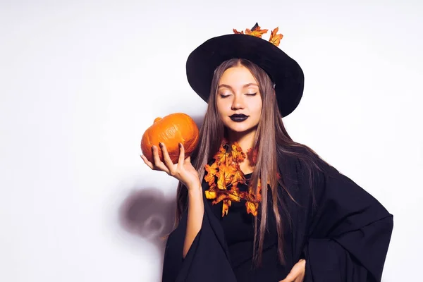 Młoda seksowna wesoły Gocki dziewczyna świętuje halloween, ubrany w czarownica, w big czarny kapelusz, posiada dyni w jej ręce — Zdjęcie stockowe