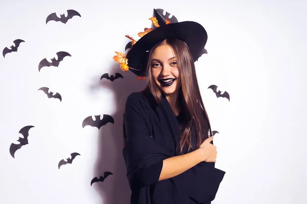 Giovane sexy allegra ragazza gotica celebra Halloween, vestita con una strega, con un grande cappello nero, ride — Foto Stock