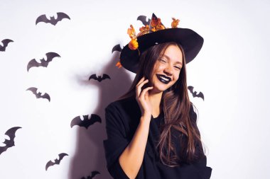 genç bir Gotik seksi Gotik kız Cadılar Bayramı, cadı, resimde kafasına sarı sonbahar ile süslenmiş büyük bir siyah şapka bırakır kutluyor