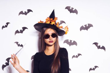 bir genç, Gotik, seksi Gotik kız Cadılar Bayramı, bir sihirli değnek tutan güneş gözlüğü, takmış bir cadı, resimdeki kutluyor.