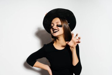 genç bir Gotik seksi Gotik kız Cadılar Bayramı, cadı, resimde kafasına sarı sonbahar ile süslenmiş büyük bir siyah şapka bırakır kutluyor