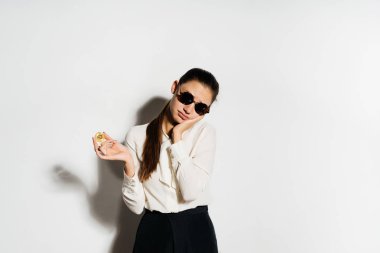 güneş gözlüklü genç modern bir başarılı kız altın bitcoin tutuyor