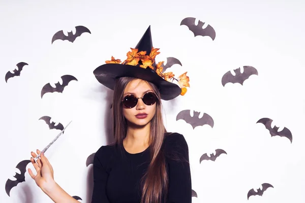 Szexi, fiatal, gothic gothic lány ünnepli a halloween, a képen egy boszorkány, napszemüveget visel, gazdaság egy varázspálca — Stock Fotó