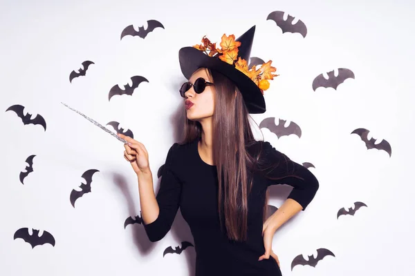 Una joven, gótica, sexy chica gótica celebra halloween, en la imagen de una bruja, con gafas de sol, sosteniendo una varita mágica —  Fotos de Stock