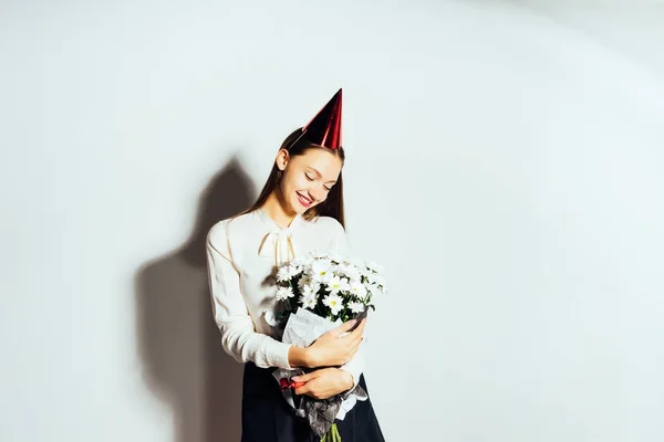 Mooi meisje viert iets, houdt in haar hand een groot boeket van witte bloemen — Stockfoto