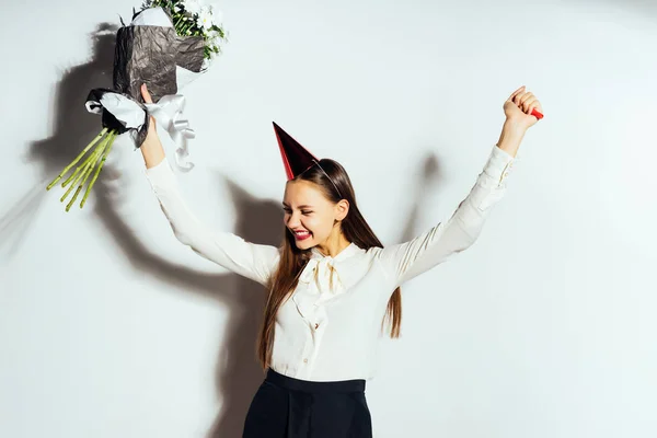 Jovem menina bonita celebra algo, segura em sua mão um grande buquê de flores brancas — Fotografia de Stock