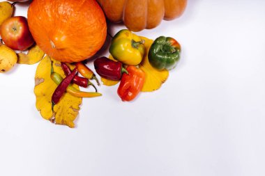 Cadılar Bayramı'nda, beyaz bir tablo üzerinde bir ev dekorasyon için kompozisyon yalan turuncu ve sarı kabak, sonbahar sarı yaprak ve meyve ve sebze