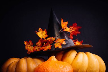 Cadılar Bayramı için bir ev dekorasyon için bir kompozisyon yalan turuncu ve sarı kabak, büyük kara cadı şapkası