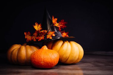 Cadılar Bayramı için bir ev dekorasyon için bir kompozisyon yalan turuncu ve sarı kabak, büyük kara cadı şapkası