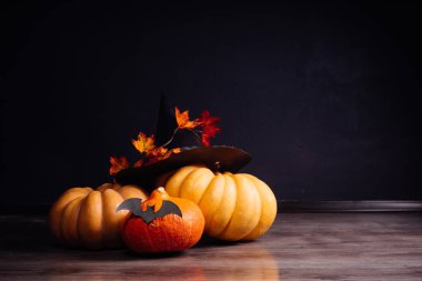 Cadılar Bayramı için bir ev dekorasyon için bir kompozisyon yalan turuncu ve sarı kabak, büyük kara cadı şapkası