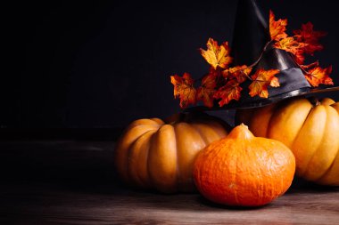 Cadılar Bayramı için bir ev dekorasyon için bir kompozisyon yalan turuncu ve sarı kabak, büyük kara cadı şapkası