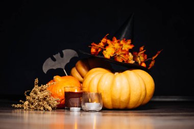 Cadılar Bayramı için bir ev dekorasyon için bir kompozisyon yalan turuncu ve sarı kabak, büyük kara cadı şapkası