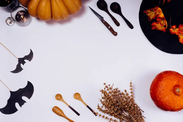 Komposition zur Dekoration eines Hauses zu Halloween, auf einem weißen Tisch liegen orange und gelbe Kürbisse, herbstgelbe Blätter — Stockfoto