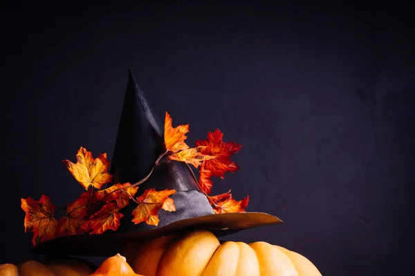 En komposition för att dekorera ett hus för halloween, orange pumpor, en stor svart häxa hatt — Stockfoto
