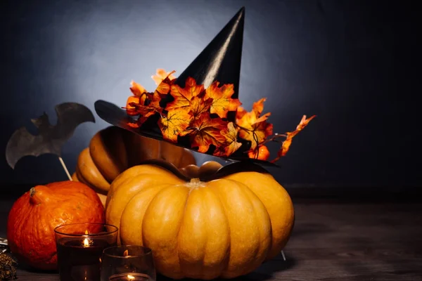 En komposition för att dekorera ett hus för halloween, ligga orange och gula pumpor, en stor svart häxa hatt — Stockfoto