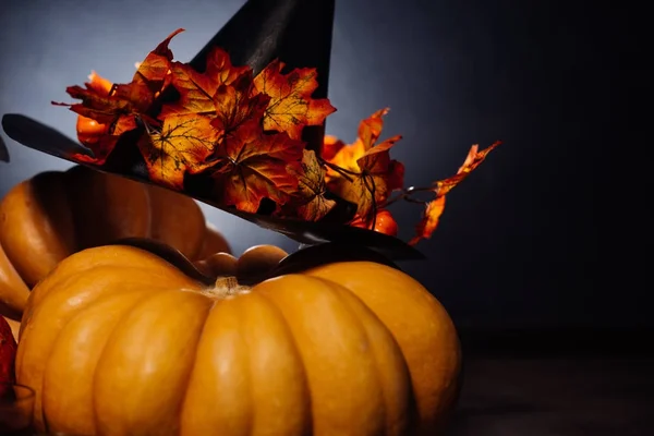 Skladba pro dekoraci na halloween, dům leží oranžové a žluté dýně, velké černé čarodějnice klobouk — Stock fotografie