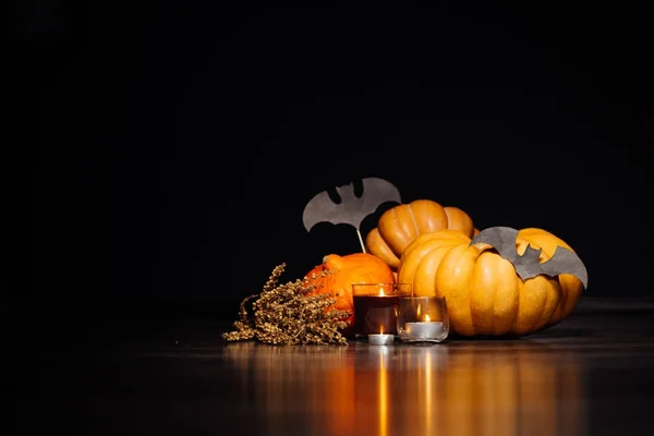 Samenstelling voor het verfraaien van een huis voor halloween, oranje en gele pompoenen liggen, de kaarsen branden — Stockfoto