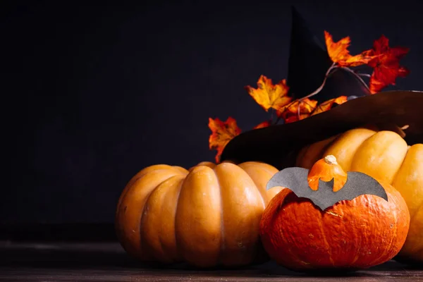 En komposition för att dekorera ett hus för halloween, orange pumpor, en stor svart häxa hatt — Stockfoto