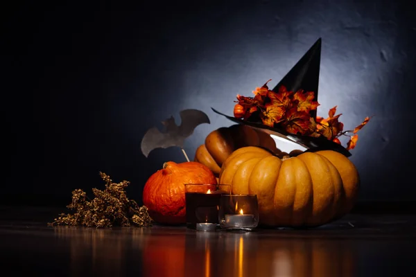 En komposition för att dekorera ett hus för halloween, ligga orange och gula pumpor, en stor svart häxa hatt — Stockfoto