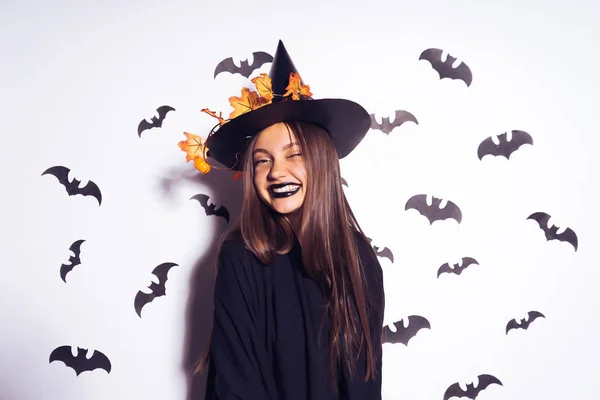 Giovane ragazza gotica sexy celebra Halloween, a immagine di una strega, in un grande cappello, ride — Foto Stock