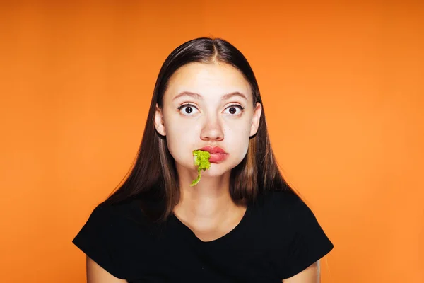 Ein junges lustiges Mädchen will abnehmen, isst aber eifrig einen schädlichen Kalorienburger — Stockfoto
