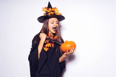 bir kız bir cadı kostüm onun elinde küçük bir kabak dilim çalışır