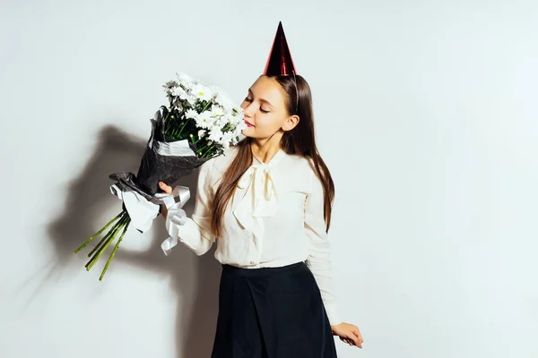 En flicka i en festlig hatt har doften av blommor — Stockfoto