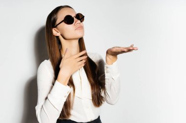 uzun saçlı modern kız siyah güneş gözlüğü ve altın bitcoin tutan Kripto para birimi hakkında düşünüyor