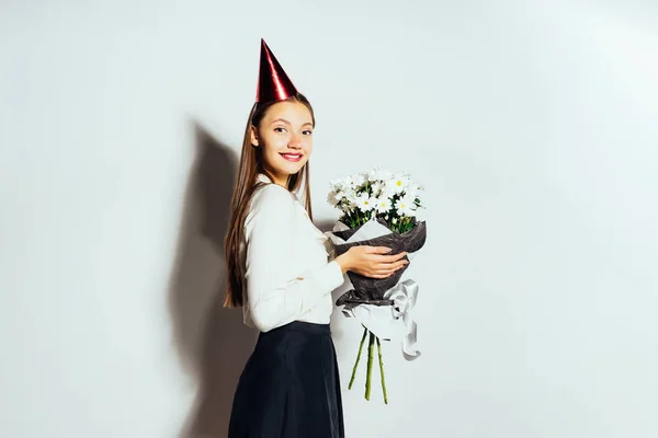 Bonito engraçado engraçado engraçado menina segurando um buquê de flores brancas e sorrindo — Fotografia de Stock