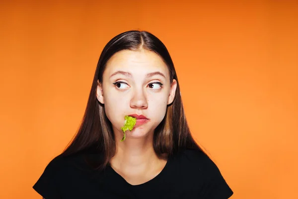 Jovem menina triste tentando perder peso, comer verduras e triste procurando em algum lugar — Fotografia de Stock